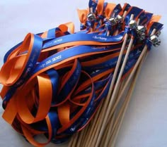 a bunch of orange and blue streamers next to two wooden chopsticks on a white surface