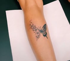 a woman's arm with a butterfly tattoo on it