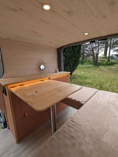 the inside of a camper with a wooden table and bench in front of it