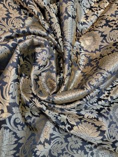 a blue and gold brocaded fabric with an intricate design on it's side