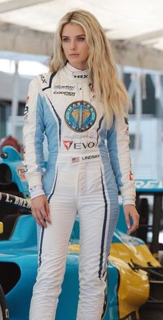 a woman standing next to a racing car