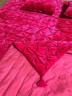 a bed covered in pink sheets and pillows