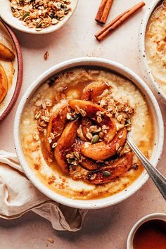 a bowl of oatmeal with cinnamon and nuts on top, surrounded by other bowls