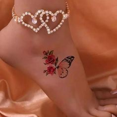 a woman's foot with a butterfly and rose tattoo on the side of her leg