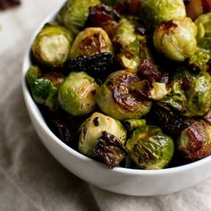 a white bowl filled with brussel sprouts on top of a table