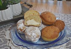 a glass plate topped with donuts on top of a table next to a potted plant