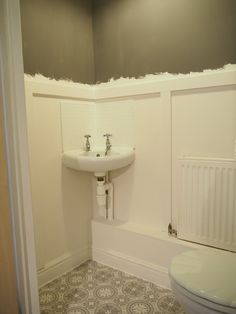 a bathroom with a toilet, sink and radiator is shown in this image