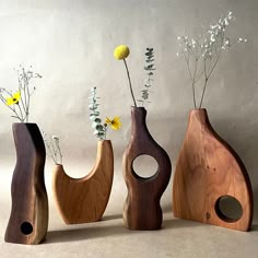 three wooden vases with flowers in them