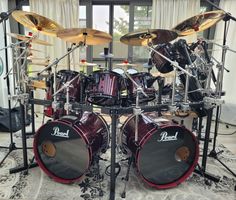 a red drum set sitting on top of a rug in front of a glass window