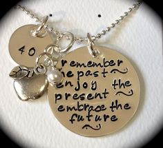 a couple of necklaces that have some charms on them with the words, remember the past and enjoy the present exchange the future