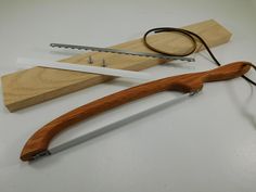 a pair of scissors sitting on top of a piece of wood next to a knife