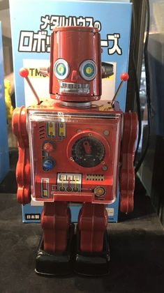 a red robot toy sitting on top of a table