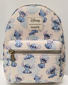 The photos for this listing are stock photos. This means that the print design on the bag shown in the pictures is not necessarily the exact bag that you will receive. It will have all the same characters. They just might be featured in different locations on the bag. This Loungefly Disney Lilo & Stitch Tropical Leaves Mini Backpack is perfect for any Disney fan! With a cute Stitch character design and tropical leaves accents, this backpack is a must-have accessory. The white handle/strap and brass hardware color create a stylish contrast with the multicolor exterior material of polyurethane. It's the perfect size for carrying your essentials, and the backpack style makes it easy and comfortable to wear for any occasion. Add this to your collection today! Approximate Size: 8 x 5 x 11 Inche Stitch Character Design, Lilo And Stitch Toys, Lilo And Stitch Merchandise, ليلو وستيتش, Lilo And Stitch Quotes, Stitch Backpack, Stitch Toy, Lilo And Stitch Drawings, Stitch Character