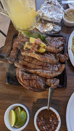 the steak is prepared and ready to be served with salsa, limes, and other condiments