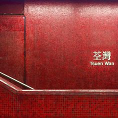 a red tiled wall with the words tsueen wan on it