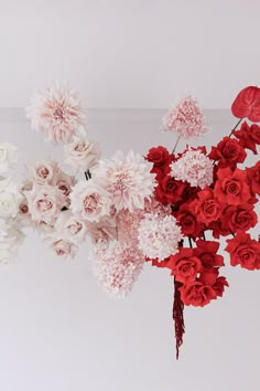 red and white flowers are arranged in a vase