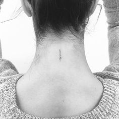 the back of a woman's neck with an arrow tattoo on it