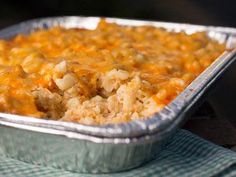 a casserole dish with cheese and meat in it on a blue cloth napkin