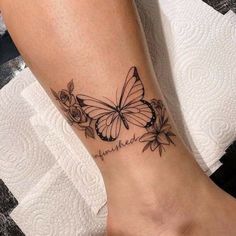 a woman's foot with a butterfly and roses tattoo on the left side of her leg