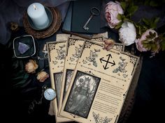 three tarot cards sitting on top of a table next to a candle and some flowers