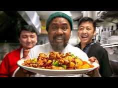 two men are holding a plate with food on it and one man is smiling at the camera