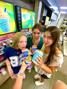 three girls in a convenience store drinking sodas