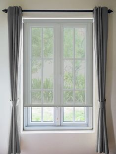 an open window in a white room with curtains