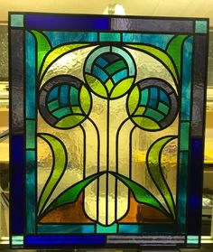 a stained glass window with green leaves on it