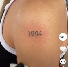 the back of a woman's shoulder with numbers tattooed on it