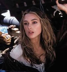 a beautiful young woman sitting under a boat