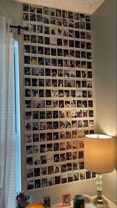 a room with pictures on the wall and a lamp in front of it next to a window