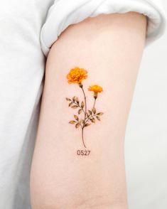 a small yellow flower tattoo on the arm