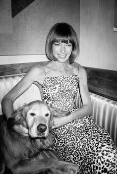 a black and white photo of a woman sitting on a couch next to a dog