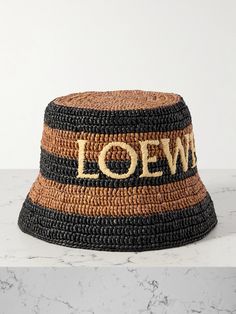 Made in collaboration with Paula's Ibiza, Loewe's striped bucket hat is perfect for your next tropical vacation. It's woven from lightweight raffia, embroidered with the brand's logo and has a substantial brim to shield your face from the harsh sun. Spring Straw Bucket Hat, Woven Summer Bucket Hat, Woven Bucket Hats For Summer, Summer Vacation Hats With Embroidered Logo, Summer Wide Brim Hat With Embroidered Logo, Rafia Hat, Striped Bucket Hat, Raffia Bucket Hat, Loewe Paula's Ibiza