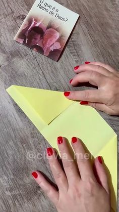 a woman is making an origami flower out of paper