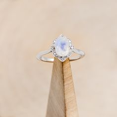 a close up of a ring on top of a piece of wood with a stone in the middle