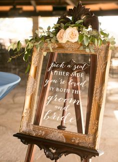 a wooden easer holding a sign that says pick a seat, either side you're loved by both the groom and bride