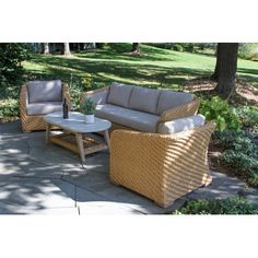 two wicker couches and a coffee table on a patio