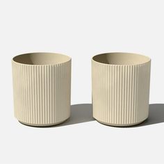 two white cups sitting next to each other