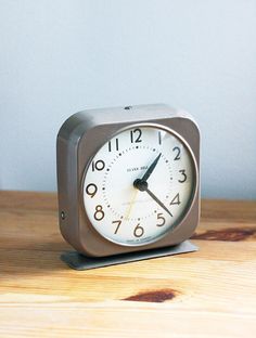 an alarm clock sitting on top of a wooden table