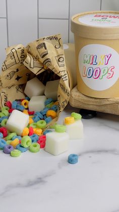 a bowl of cereal next to a bag of candy loops and a container of ice cream