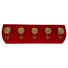 four brass knobs on a red velvet holder