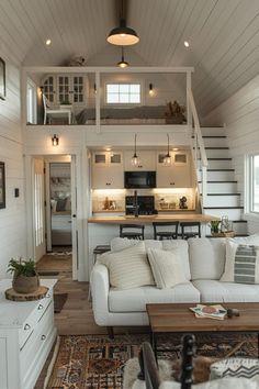 a living room filled with furniture next to a kitchen and dining area in a house