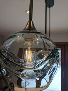 a glass light fixture hanging from the ceiling