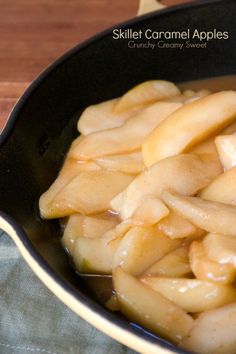 a pan filled with sliced apples on top of a wooden table