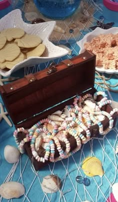 an open trunk sitting on top of a table filled with cookies and other food items