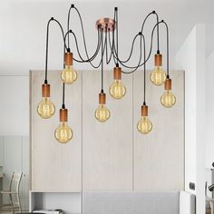 a bunch of light bulbs hanging from the ceiling above a bed in a room with white walls