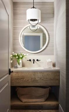 a bathroom sink with a mirror above it and a vase on the counter next to it