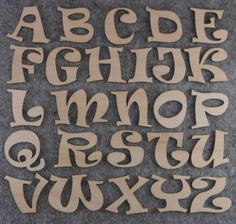 wooden letters and numbers are laid out on the floor to be used as wall hangings