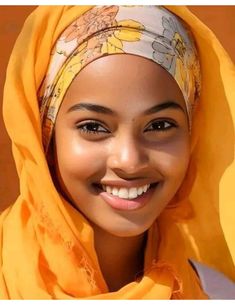 a smiling woman wearing a yellow head scarf